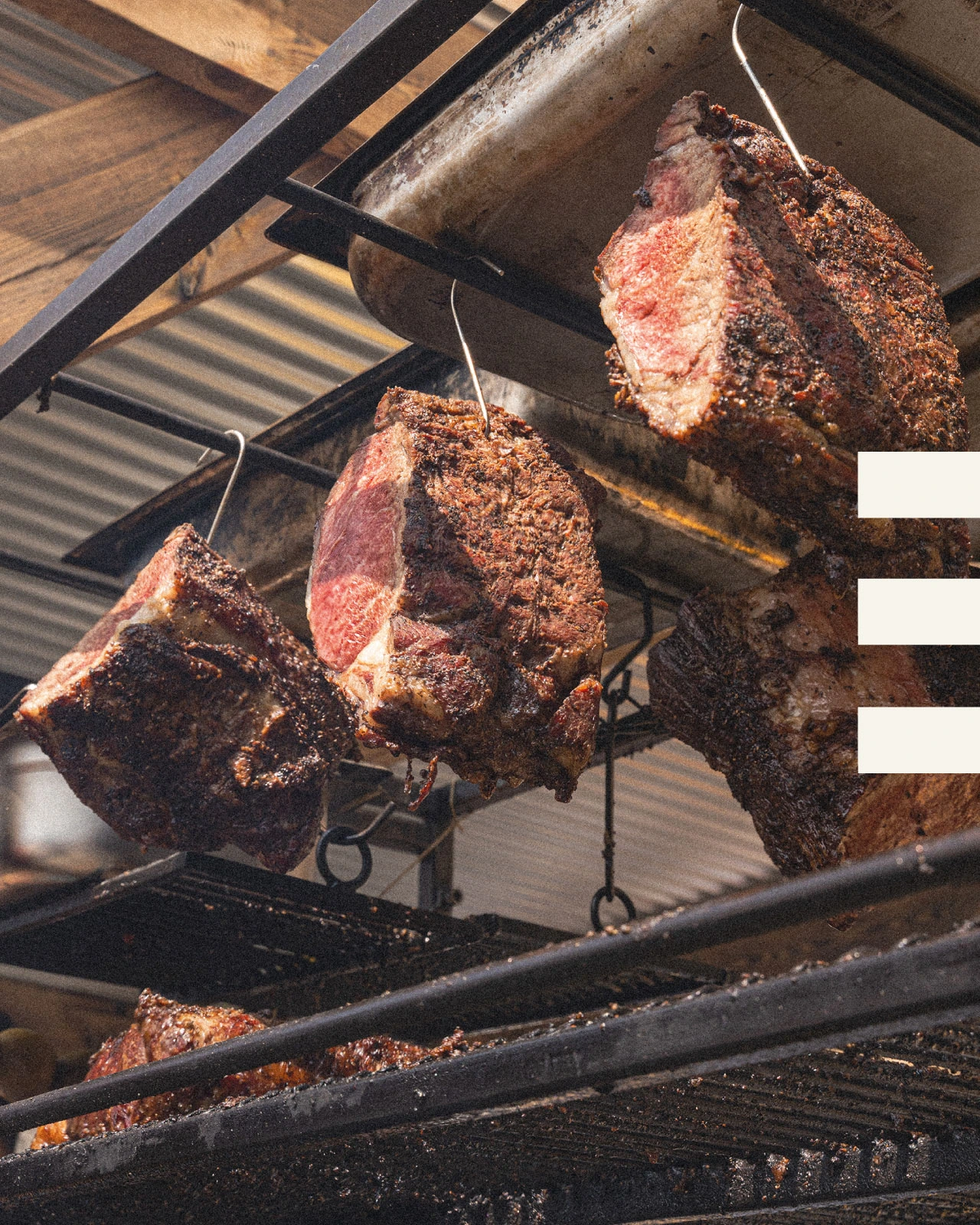 Cuts of meat cooking over the fire in Tiberius’s smokehouse portfolio