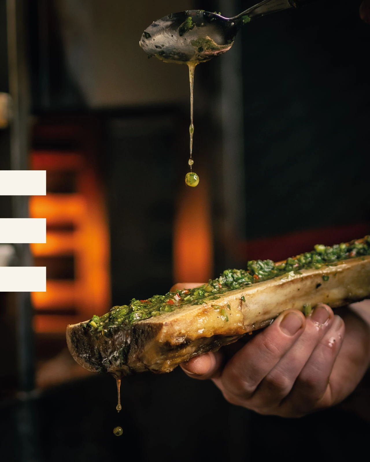 Herbs and oil finishing roasted bone marrow in Tiberius’s portfolio
